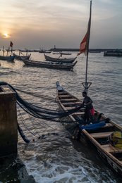 Accra;-Ghana;-Jamestown;-fishing-harbour;-fisherman;-fishing-net;-pirogue;-flag;-silhouette;-backlight;-sunrise;-raking-light;-artisanal-fishing;-fishing-community;-Gulf-of-Guinea;-West-Africa;-historic-district;-documentary-photography;-Kaleidos;-Kaleidos-images;-La-parole-à-limage;-Stories-Pictures;-Tarek-Charara